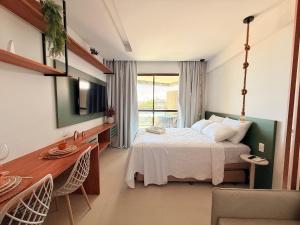 a bedroom with a bed and a table and a television at Açores Tamandaré Flats By HM in Tamandaré +176 photos