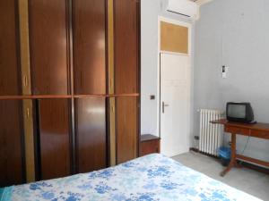 1 dormitorio con armario de madera y cama en Casa di Roma en Roma