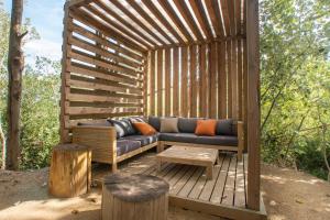 a wooden pergola with a couch sitting on a deck at Turismo Rural Mas Ametller in Fontclara