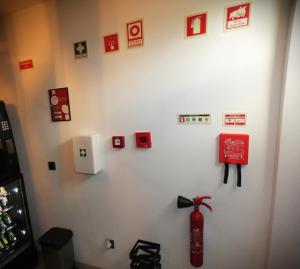 a white wall with many pictures and a fire extinguisher at Pinhal Litoral in Marinha Grande