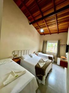 a bedroom with two beds and a window at Pousada Maré Mansa in Paraty