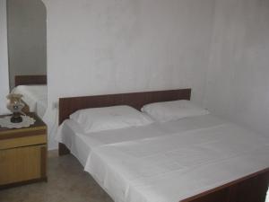 a bedroom with two beds and a nightstand with a white bed at Apartment Mit Terrasse Direkt Am Meer in Betina