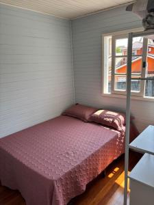 a bed in a small room with a window at Casa na Beira Mar Continental in Florianópolis