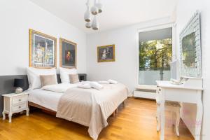 ein weißes Schlafzimmer mit einem Bett und einem Schreibtisch in der Unterkunft Your Holidays Aquamarina in Misdroy