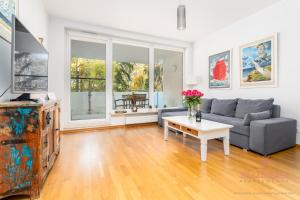 ein Wohnzimmer mit Sofa und Tisch in der Unterkunft Your Holidays Aquamarina in Misdroy