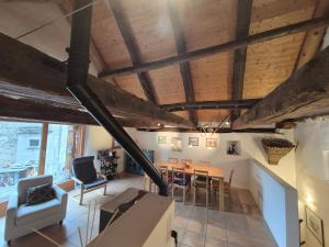 un soggiorno con soffitti in legno, tavolo e sedie di Stalla di Adele a Cevio