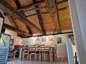 una sala da pranzo con soffitti in legno, tavolo e sedie di Stalla di Adele a Cevio
