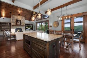 eine Küche und ein Esszimmer mit einem Tisch und einem Kamin in der Unterkunft Morning Glow - Luxury Mountain Cabin in Blue Ridge in Ballew Mill