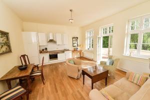 a kitchen and living room with a table and chairs at Wohnung Im Zweiten Obergeschoss Des Gutshauses in Neuenkirchen