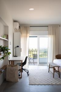 a bedroom with a desk and a bed and a balcony at Outsite Sagres - Work, Connect, Explore in Sagres +21 photos