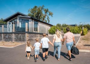 a family walking down a road towards a house at Windmill Retreat in Middlezoy
