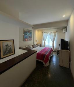 ein Hotelzimmer mit einem Bett und einem Fernseher in der Unterkunft Tayka Suites Apart Hotel in Salta + 28 Fotos