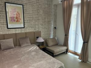 a bedroom with a bed and a chair and a brick wall at Typic loft Alghero in Alghero