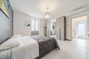 - une chambre blanche avec un grand lit et un couloir dans l'établissement Casa Mimmo - close to the airport & private parking, à Azzano San Paolo