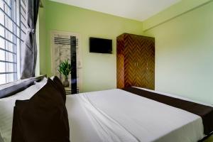 Un dormitorio con una cama blanca y un televisor. en Collection O MKU Madurai Formerly Mpl Elite, en Samayanallūr 21 fotos más