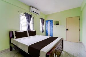 un dormitorio con una cama grande en una habitación en Collection O MKU Madurai Formerly Mpl Elite, en Samayanallūr
