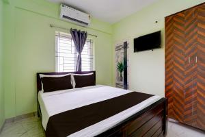 un dormitorio con una cama y una ventana en Collection O MKU Madurai Formerly Mpl Elite, en Samayanallūr