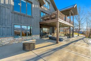 a large house with a deck and a balcony at Windriver Hideaway - Private Hot Tub in Wolf Creek Village