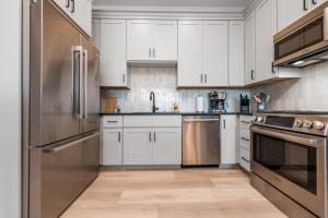 une cuisine avec des armoires blanches et des appareils en acier inoxydable dans l'établissement Cliffside Modern Villa - Lower Level, à La Verkin