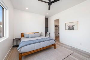 une chambre avec un lit et un mur blanc dans l'établissement Cliffside Modern Villa - Hot Tub Stunning Views, à La Verkin 50 autres photos