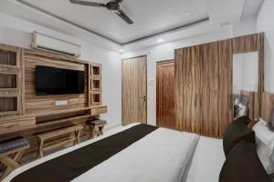 um quarto com uma cama grande e uma TV de tela plana em Hotel O OM SAI HOTEL em Kākori