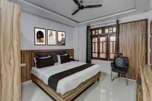 um quarto com uma cama grande e uma cadeira em Hotel O OM SAI HOTEL em Kākori