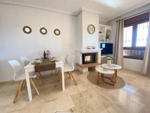 a living room with a table and chairs and a fireplace at Casa Kessing in Orihuela Costa