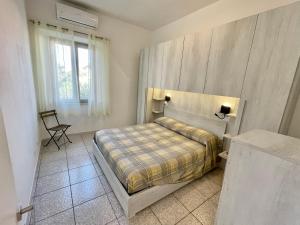 een slaapkamer met een bed en een stoel erin bij Appartamenti Marisol in Marina di Campo