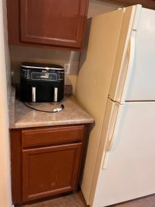 a kitchen with a black microwave on a counter next to a refrigerator at Westgate Tiny Room 94th in Phoenix