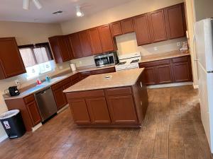 a kitchen with wooden cabinets and a counter top at Westgate Tiny Room 94th in Phoenix