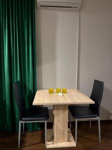 a table with two chairs and a green curtain at Modern Apartment 2 in Brčko