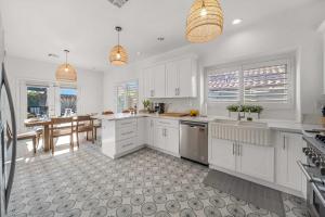 uma cozinha com armários brancos e uma sala de jantar em Casa Milan Oasis Private Pool Spa & Mountain View em Bermuda Dunes