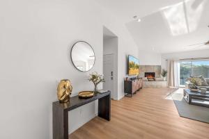 uma sala de estar com paredes brancas e um espelho em Casa Milan Oasis Private Pool Spa & Mountain View em Bermuda Dunes