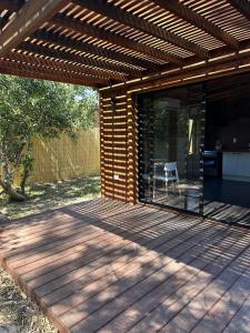 eine Terrasse mit einem Holzdeck mit Pergola in der Unterkunft Santosha in La Paloma