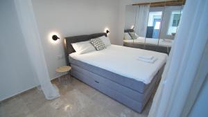 una piccola camera da letto con un letto e uno specchio di Casa Bianca a Skopelos Town