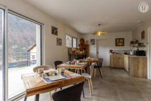 a dining room with tables and a large window at Coeur de fournache in Saint-Jean-de-Maurienne