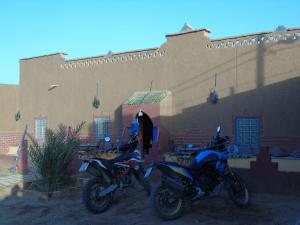 un par de motocicletas estacionadas frente a un edificio en Kasbah Dar Lgamra, en Merzouga 22 fotos más