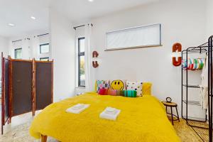 a bedroom with a large bed with yellow blanket at The HUB in Eugene