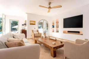 a living room with a couch and a tv on a wall at Beautiful Sea View Villa Minerva in Sant Josep