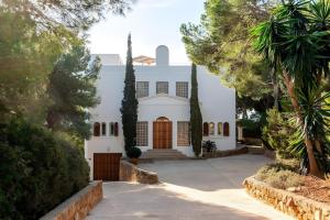 a large white house with trees and a driveway at Beautiful Sea View Villa Minerva in Sant Josep