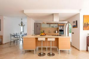 a kitchen with a large island with bar stools at Beautiful Sea View Villa Minerva in Sant Josep