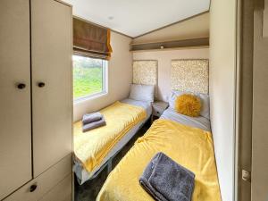 Un dormitorio pequeño con dos camas y una ventana. en Skokholm, en Walton West