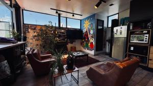 a living room with couches and chairs and windows at Sumaq Hostel Backpackers in Buenos Aires