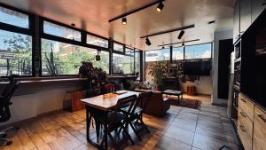 Sumaq Hostel Backpackers في بوينس آيرس: غرفة طعام مع طاولة وبعض النوافذ