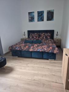 a bedroom with a bed and a wooden floor at Apartament Moniuszko in Jedlina-Zdrój