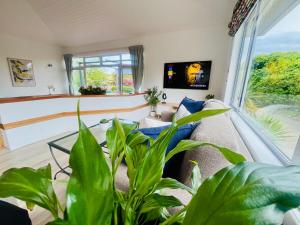 uma sala de estar com um sofá e uma janela grande em Decked Out with a View em Motueka