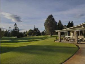 um campo de golfe com uma casa e um verde em Decked Out with a View em Motueka