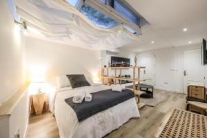 une chambre avec un grand lit avec une lucarne dans l'établissement ARCO Gran Via Boutique Apartments, à Madrid