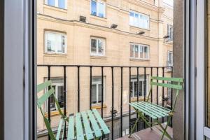 une chaise verte assise sur un balcon avec un bâtiment dans l'établissement ARCO Gran Via Boutique Apartments, à Madrid