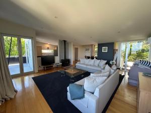 a living room with a white couch and a table at Stephens Bay Delight Kaiteriteri in Kaiteriteri